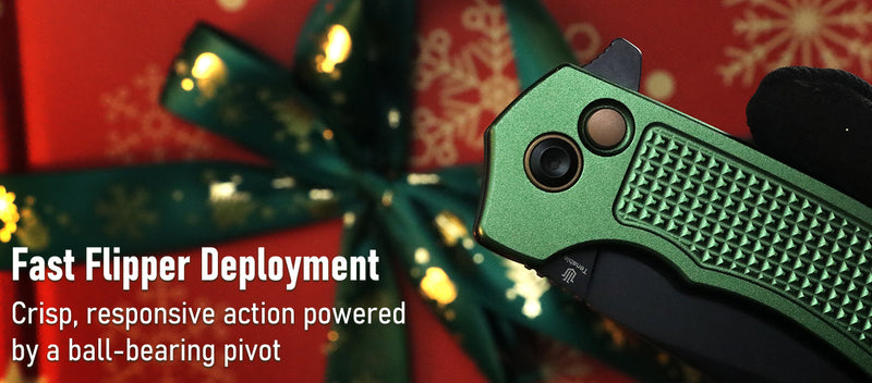 Green folding knife held by a gloved hand with Christmas decorations in the background