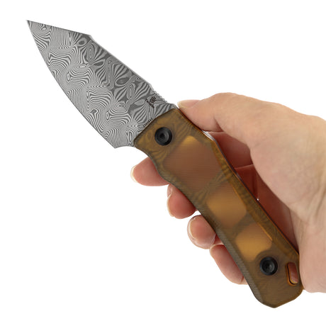 Hand holding a knife with a patterned blade and brown handle on a white background